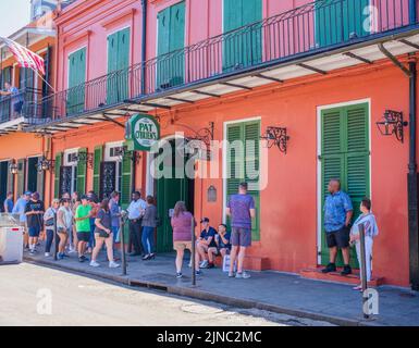 NEW ORLEANS, LA, USA - 3 APRILE 2022: Le persone che aspettano di fronte al famoso Pat o'Brien's su St. Peter Street, nel quartiere francese Foto Stock