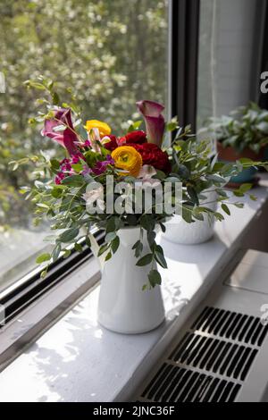 Composizione floreale con giglio di calla, ranuncolo ed eucalipto Foto Stock
