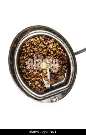 Bacche di Sumac intere essiccate non macinate in un macinacaffè di spezie top down Foto Stock