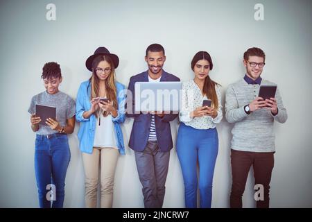 Theyve ha trovato le risorse giuste per preparazione. Studio di un gruppo di giovani uomini d'affari che utilizzano la tecnologia wireless mentre si trovano in linea con un Foto Stock