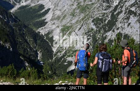 Grainau, Germania. 10th ago, 2022. Gli escursionisti si affacciano sulla valle del Höllental. Il ghiaccio del ghiacciaio Blaueis, lo Schneeferner sullo Zugspitze e il Höllentalferner sono diminuiti in modo significativo in un solo anno. (A dpa 'la polvere di Sahara sta colpendo i ghiacciai - il ghiaccio si sta sciogliendo a un ritmo record') Credit: Angelika Warmuth/dpa/Alamy Live News Foto Stock