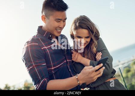 Youre cominciando a tendenza innamorato. Una giovane donna attraente che fa i volti divertenti mentre il suo ragazzo scatta le foto della sua natura. Foto Stock