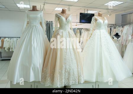 Tre eleganti abiti da sposa su manichini. Tre diversi modelli di splendidi abiti da sposa. Foto Stock