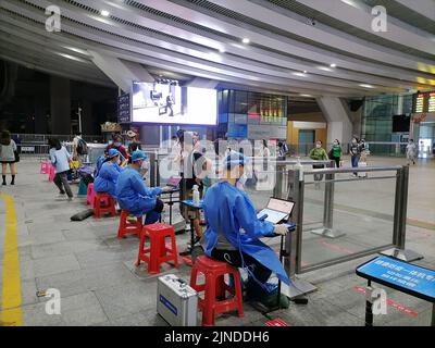 Shenzhen, Cina: I passeggeri che entrano a Shenzhen con la ferrovia ad alta velocità devono avere un codice verde di rilevamento di acido nucleico di 48 ore. A1 il personale di uscita sta verificando il Foto Stock