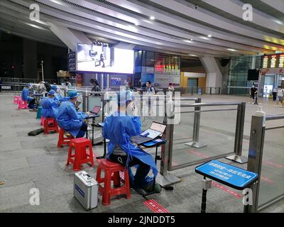 Shenzhen, Cina: I passeggeri che entrano a Shenzhen con la ferrovia ad alta velocità devono avere un codice verde di rilevamento di acido nucleico di 48 ore. A1 il personale di uscita sta verificando il Foto Stock