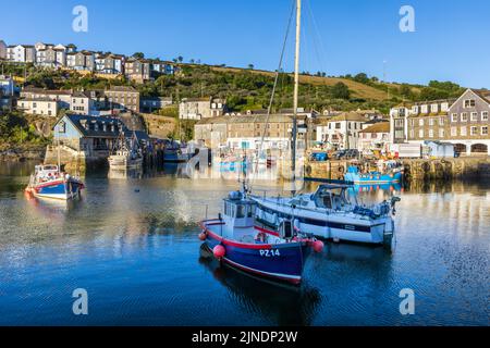 Vista sul lungomare attraverso il porto interno di Mevagissey in Cornovaglia, con il piccolo mercato del pesce sullo sfondo. Foto Stock