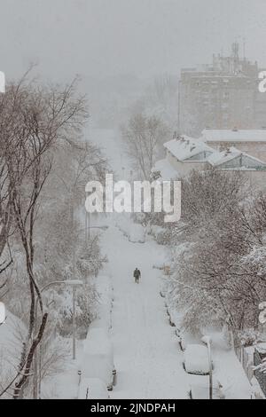 uomo che cammina da solo nella neve Foto Stock