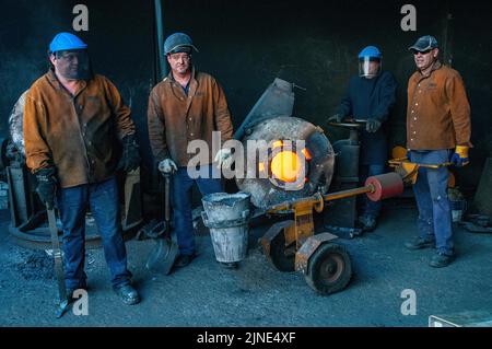 Lavoratori di fonderie in una piccola fonderia di famiglia di fusione del metallo a Perth, Australia Occidentale Foto Stock