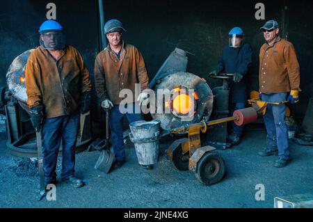 Lavoratori di fonderie in una piccola fonderia di famiglia di fusione del metallo a Perth, Australia Occidentale Foto Stock