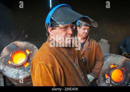 Lavoratori di fonderie in una piccola fonderia di fusione di metallo della famiglia a Perth, Australia Occidentale Foto Stock