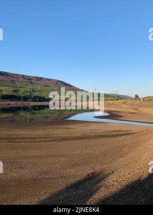 Una vista dei bassi livelli dell'acqua presso la United Utilities, Woodhead Reservoir, nel Derbyshire. L'ufficio MET ha emesso un avvertimento di calore color ambra in corso tra giovedì e domenica, che potrebbe vedere picchi di temperatura a 36C °C nell'Inghilterra meridionale e nel Galles orientale, con alcune aree che devono affrontare un rischio 'eccezionale' di incendi boschivi mentre l'indice di gravità degli incendi viene portato al livello più alto. Data immagine: Giovedì 11 agosto 2022. Foto Stock