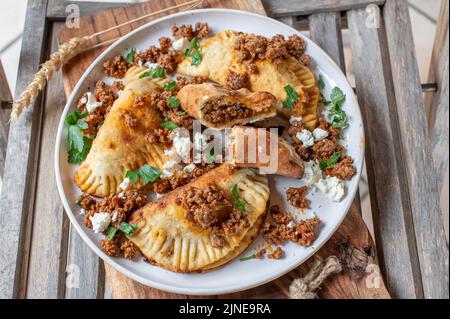 Pierogi con carne tritata piccante e feta ripieno su un piatto Foto Stock