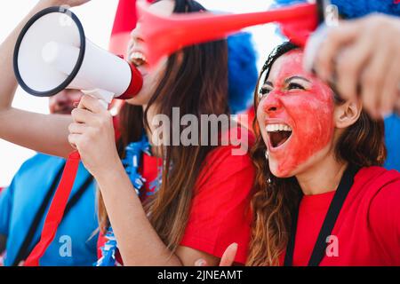 Tifosi pazzi che urlano mentre sostengono la loro squadra - Focus sulla destra occhio ragazza Foto Stock