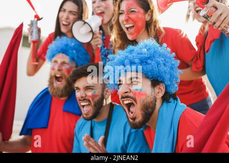 Tifosi pazzi che urlano mentre sostengono la loro squadra di calcio - fuoco morbido sulla faccia destra dell'uomo Foto Stock