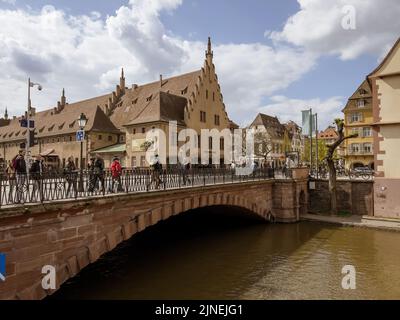 Strasburgo, Francia - 10 aprile 2022: Pedoni a piedi sul Pont du Corbeau ponte e Ancienne Douane edificio in background - visite turistiche Strasburgo Foto Stock