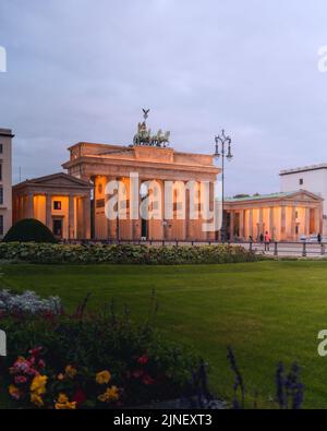 Una ripresa verticale della porta di Brandeburgo illuminata in serata Foto Stock