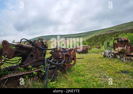 Un campo disseminato di vecchie miniere rotte, arrugginite, vecchie attrezzature di scavo, utensili. Al Big Pit National Coal Museum di Pontypool, Galles, Regno Unito. Foto Stock