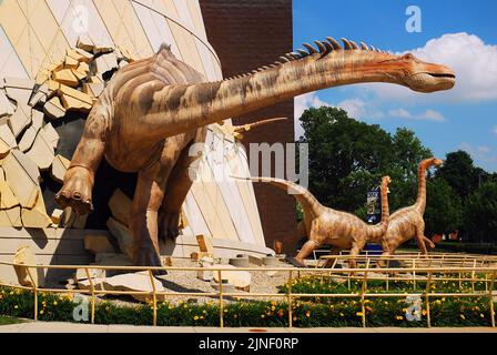 Un gruppo di dinosauri sembra uscire dalla facciata del Museo dei Bambini di Indianapolis, fornendo un'entrata stravagante all'edificio Foto Stock