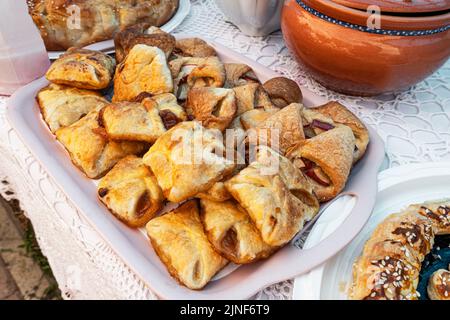 Biscotti dolci con marmellata di mele ripieno in un piatto sul tavolo Foto Stock