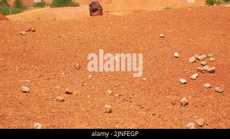 Red stones and rocks in bauxite mine. Gant, Hungary - Tele view Stock Photo