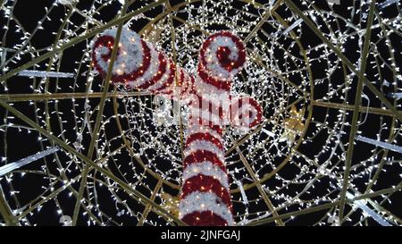 Alto albero illuminato al mercato di Natale, vista dal basso a Gyor, Ungheria Foto Stock