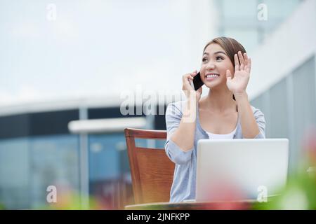 Allegro giovane busienscan parlando al telefono e agitando con qualcuno Foto Stock