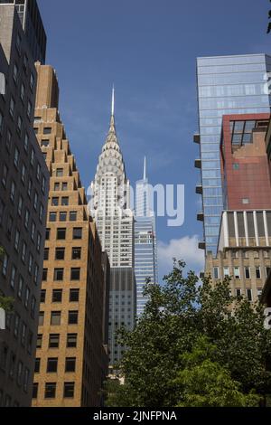 Guardando verso ovest attraverso gli alberi dall'estremità orientale della East 43rd Street, l'iconica Chrysler Tower con la nuova 1 Vanderbilt Tower è chiaramente visibile nel centro di Manhattan.