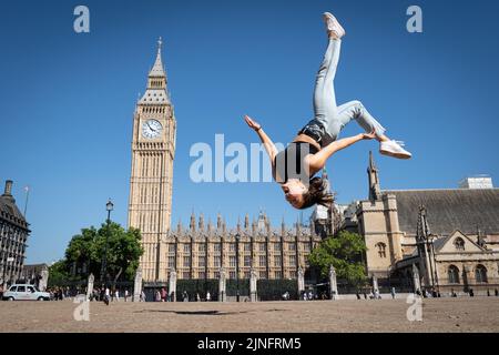 Il trampolino, Nicole Steiner, svizzero, si muove in una piazza del Parlamento seccata nel centro di Londra dopo aver gareggiato nei Campionati del mondo Freestyle Trampoline a Hackney, nella zona est di Londra. L'ufficio MET ha emesso un avvertimento di calore color ambra in corso tra giovedì e domenica, che potrebbe vedere picchi di temperatura a 36C °C nell'Inghilterra meridionale e nel Galles orientale, con alcune aree che devono affrontare un rischio 'eccezionale' di incendi boschivi mentre l'indice di gravità degli incendi viene portato al livello più alto. Data immagine: Giovedì 11 agosto 2022. Foto Stock