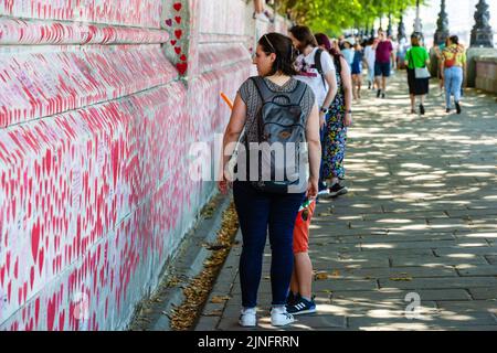 Londra, Regno Unito. 10th agosto, 2022. I membri del pubblico guardano il National Covid Memorial Wall. L'idea per il muro commemorativo è venuto da Matt Fowler An Foto Stock