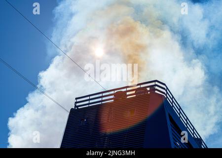 Emissioni di fumo dai tubi di scarico nell'imbuto di una nave da crociera di grandi dimensioni. Foto Stock