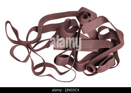 Fascia elastica isolata. Primo piano di un mucchio di nastro marrone rosso per cucire abiti isolati su sfondo bianco. Utilizzato per la fabbricazione e la riparazione di c Foto Stock