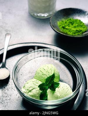 Gelato Matcha con foglia di menta su sfondo grigio chiaro Foto Stock