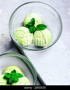 Gelato Matcha con foglia di menta su sfondo grigio chiaro Foto Stock