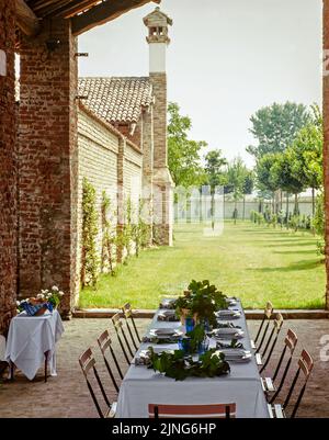 Tavoli rustici all'aperto decorati con foglie di vite. Foto Stock