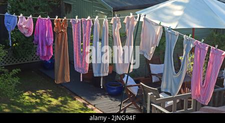 Tipica linea di lavaggio del giardino sul retro, con i vestiti che asciugano sotto il sole caldo e la brezza, piuttosto che sprecare elettricità in asciugatrice Foto Stock