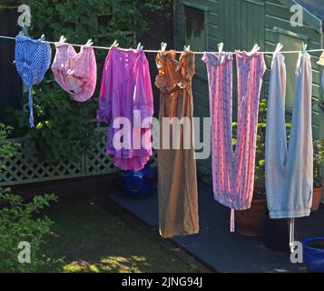 Tipica linea di lavaggio del giardino sul retro, con i vestiti che asciugano sotto il sole caldo e la brezza, piuttosto che sprecare elettricità in asciugatrice Foto Stock
