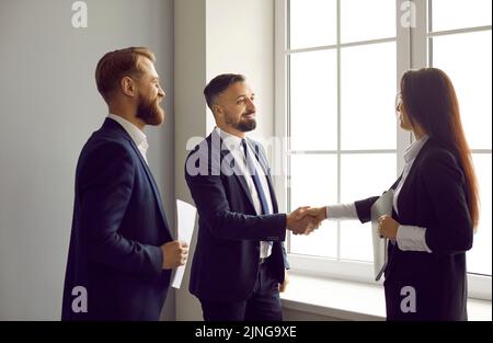 Incontri di lavoro felici, fare un accordo di partnership e scambiare handshake Foto Stock