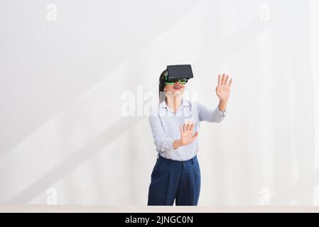 Sorridente giovane donna d'affari in occhiali vr che la toccano Foto Stock