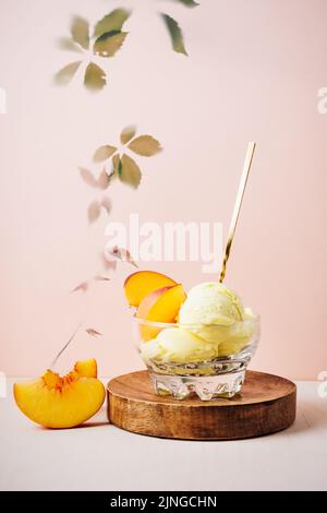 Bicchiere di gelato alla pesca con cucchiaio. Foto Stock