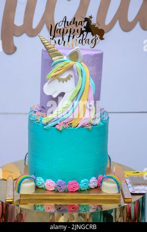 Festa di compleanno della bambina; tavolo da dessert con una bella torta di unicorno, dolci, biscotti allo zucchero e decorazione di compleanno Foto Stock