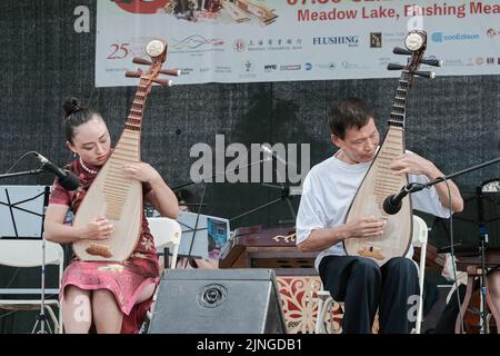 Due membri dell'ensemble musicale cinese di New York suonano la pipa, uno strumento tradizionale cinese. Al Dragon Boat Festival di Hong Kong nel Queens. Foto Stock