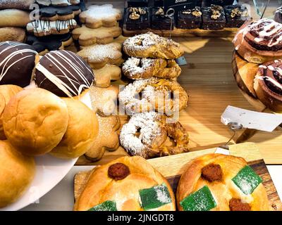 Un mix di dolci appena sfornati esposti in un negozio di panetterie Foto Stock