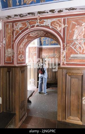 Vilnius tourist - una donna che guarda l'arte - il murale murale e gli affreschi di Petras Repsys, Vilnius University, Lituania Europe; viaggio lituano. Foto Stock