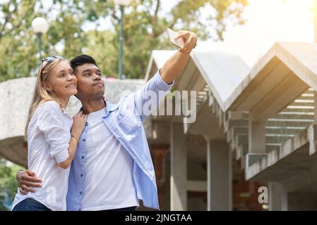 Coppia mista che ama portare il selfie con lo smartphone insieme Foto Stock
