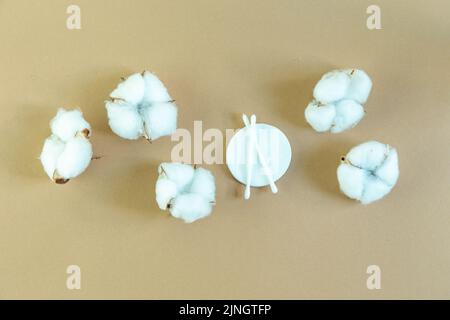 Tondini in cotone e tamponi in cotone per rimuovere il trucco su sfondo beige. Concetto di ecologia e consumo consapevole. Foto Stock