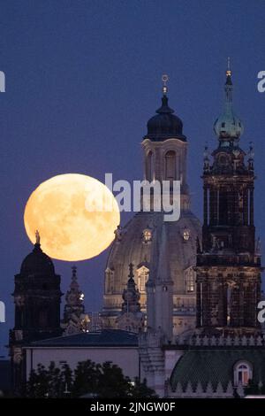 Dresda, Germania. 11th ago, 2022. La luna sorge dietro lo sfondo del Ständehaus (l-r), della Frauenkirche e della Hofkirche cattolica. Credit: Sebastian Kahnert/dpa/Alamy Live News Foto Stock
