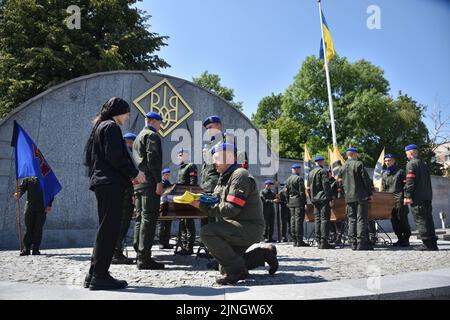 29 luglio 2022, Lviv, Ucraina: Un ufficiale militare consegna la bandiera dell'Ucraina alla moglie civile del giovane sergente Vitaly Borysyuk durante la cerimonia funeraria. I funerali di Vasyl Sushchuk del Reggimento militare Azov e del Sergente Junior Vitaly Borysyuk, morto per mano delle truppe russe durante l'invasione militare russa dell'Ucraina, si svolsero a Lviv. Vasyl Suschuk ha partecipato a speciali missioni di salvataggio presso l'impianto metallurgico ''Azovstal'' nella città di Mariupol, nella regione di Donetsk. Fu uno dei 72nd soldati che sbarcarono alla pianta. (Credit Image: © Pavlo Palamarchuk/SOPA im Foto Stock