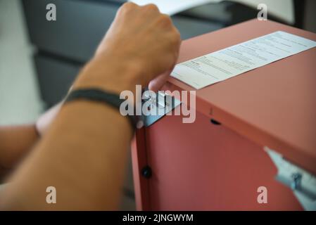 Carpentiere che lavora con cura assemblando un mobile. Foto Stock