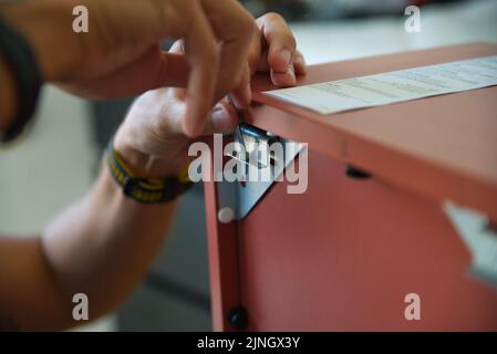 Carpentiere che lavora con cura assemblando un mobile. Foto Stock