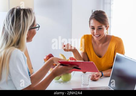 Nutrizionista professionista che incontra un paziente nell'ufficio.giovane nutrizionista sorridente femminile nella sala di consultazione. Banco nutrizionista con frutta Foto Stock